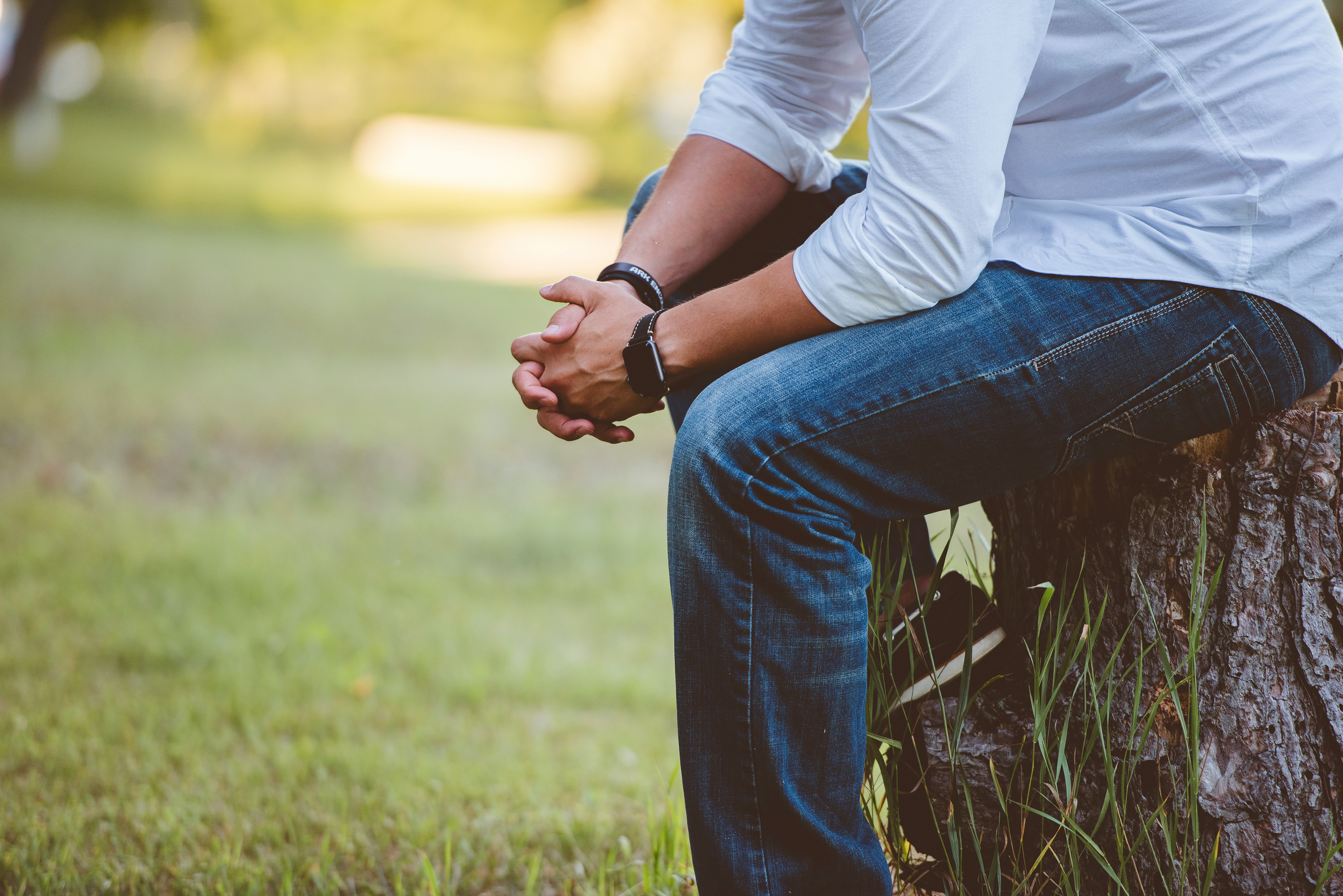 man wearing long sleeved shirt sitting